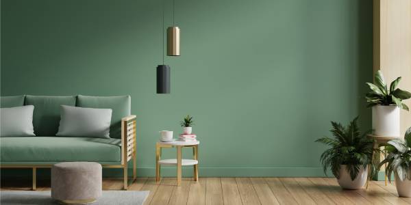 Pared pintada en verde salvia tendencia 2026 en salón con madera y textiles naturales